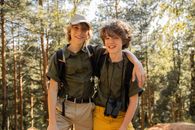 2 Women in Black and Brown Camouflage Uniform Standing Near Trees