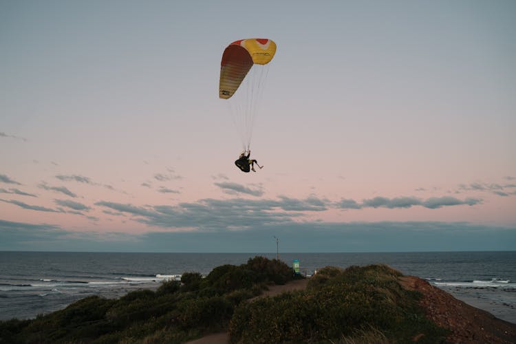 Man Paragliding Over The Sea