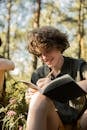 Boy Writing in a Notebook in Forest