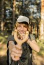 Boy Wearing Hat Aiming a Slingshot at the Camera