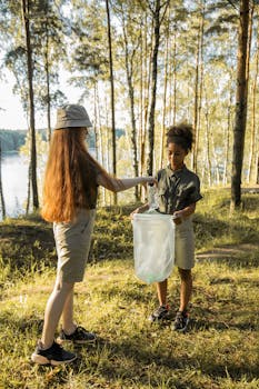 两个青少年在森林里收集垃圾，以促进回收和环境保护