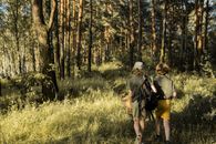 Man and Woman Walking on Green Grass Field