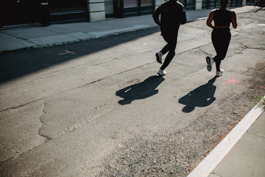 Silhouetted joggers run along a city street, capturing movement and urban fitness.