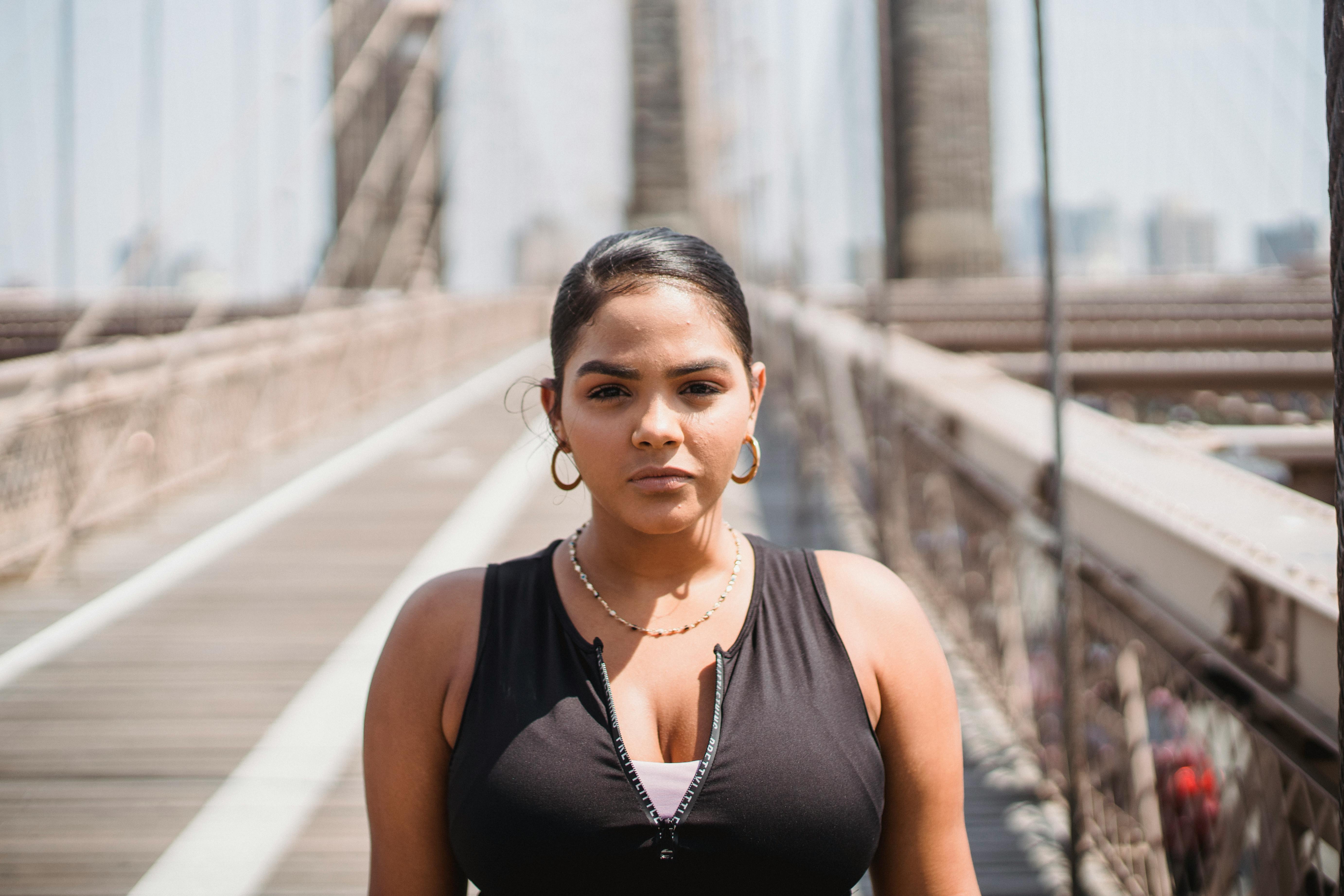 在夏天的阳光下，自信的女人站在布鲁克林大桥上