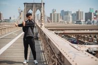 一名男子在纽约市布鲁克林大桥上穿着运动服装做伸展运动