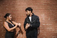 Man in Black Coat Standing Beside Woman in Black Sleeveless Dress