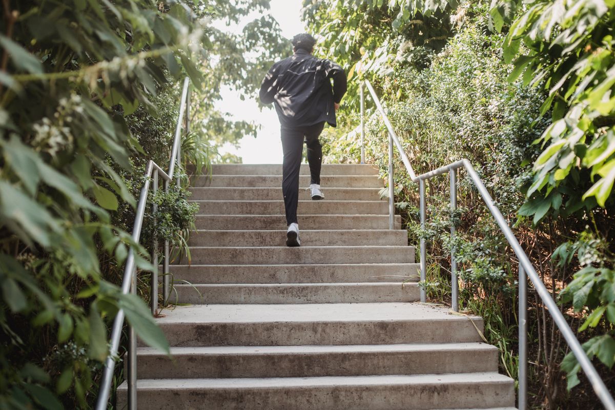 Man running up concrete steps during outdoor cardio training