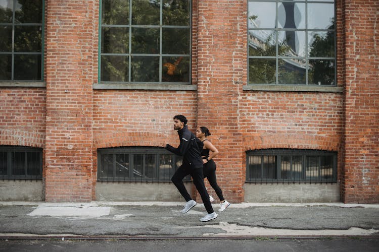 Photo Of A Couple Running Together On The Street