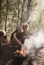 Man and Woman Sitting on Brown Wooden Bench in Front of Bonfire