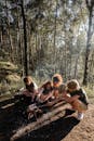 People Sitting on Ground Surrounded by Trees