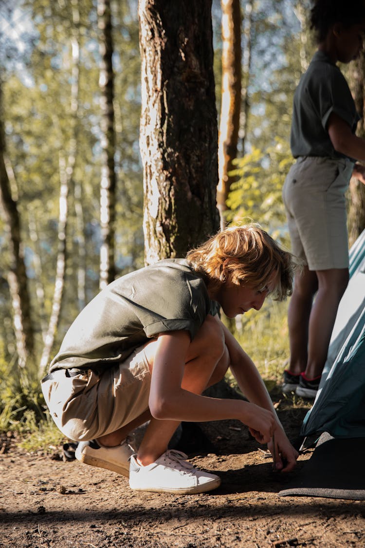 Scouts Setting Up A Tent In Forest