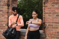 Man in Brown Polo Shirt Holding Woman in Black Tank Top