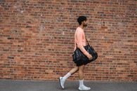 Man in Pink Dress Shirt and Black Skirt Walking on Sidewalk