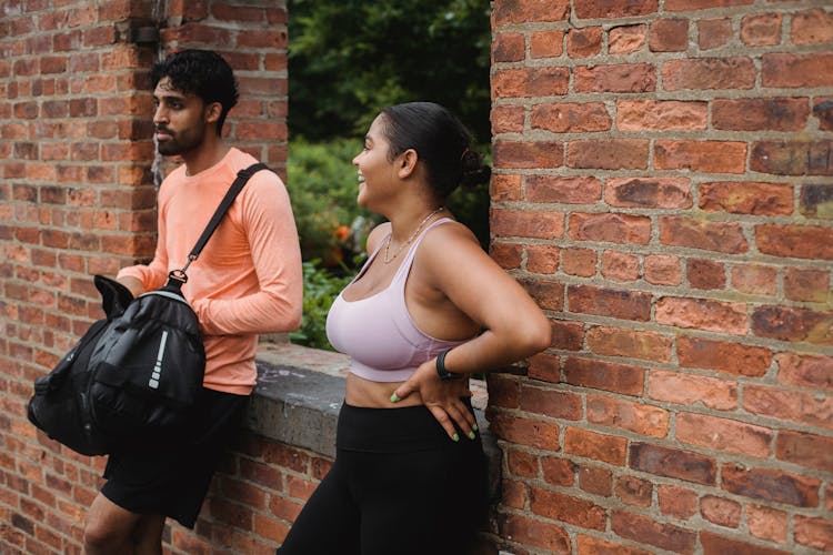 Man And Woman Standing And Talking After Exercising Outdoors