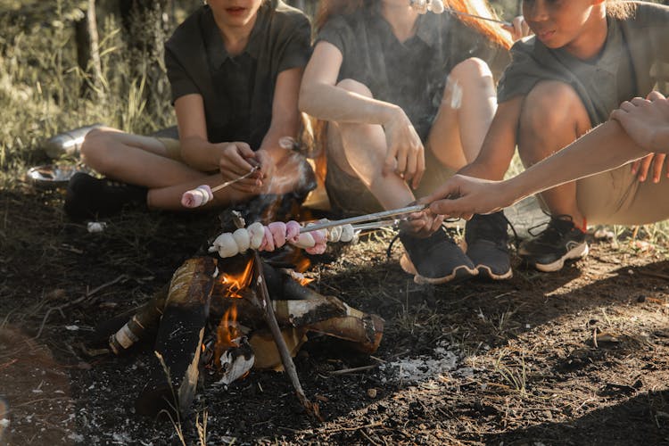 People Heating Food On The Fire