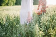 Woman in White Dress Holding Man in Orange and White Plaid Dress Shirt