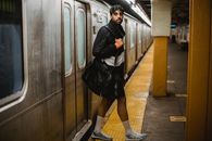 Woman in Black Leather Jacket and Black Skirt Standing on Train Station