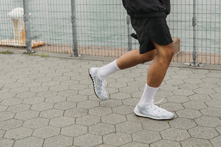 Close-up Of Man In Sneakers Running On Street