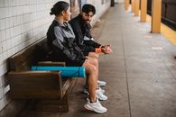 Woman in Black Jacket Sitting on Brown Wooden Bench