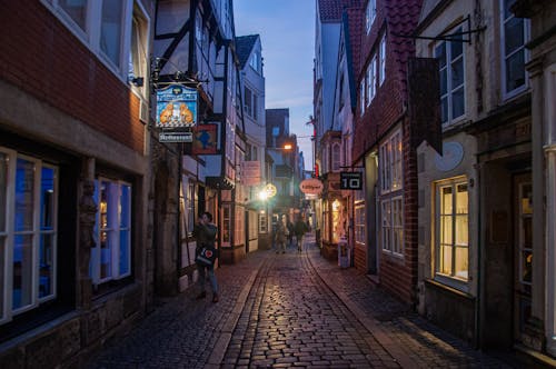 People Walking on the Street Between Buildings