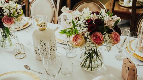 Free An elegant wedding table setup featuring beautiful rose bouquets, tableware, and gifts, perfect for special celebrations. Stock Photo