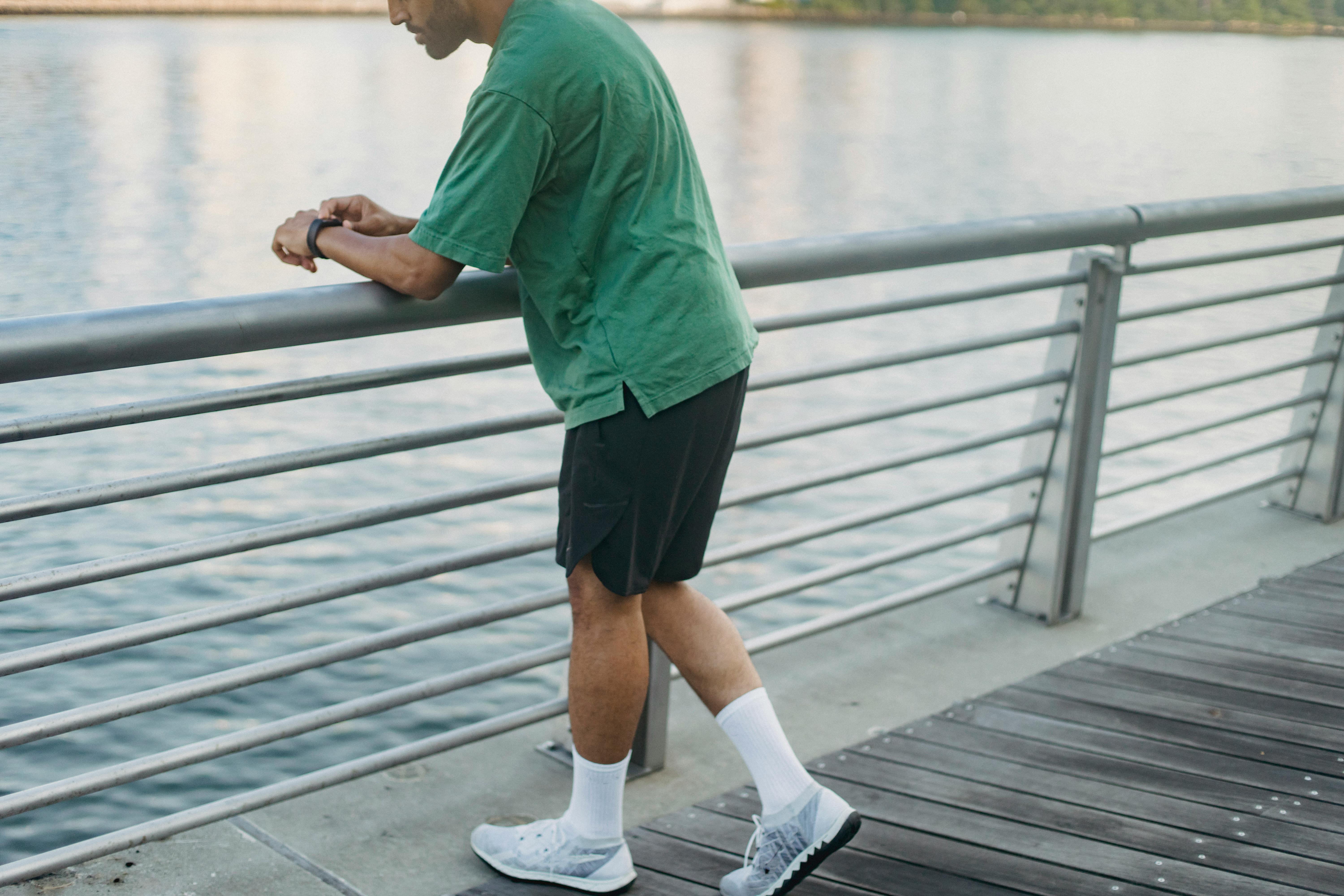 日落时分，男人在户外靠着水边的栏杆，享受休闲时光
