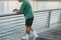 日落时分，男人在户外靠着水边的栏杆，享受休闲时光