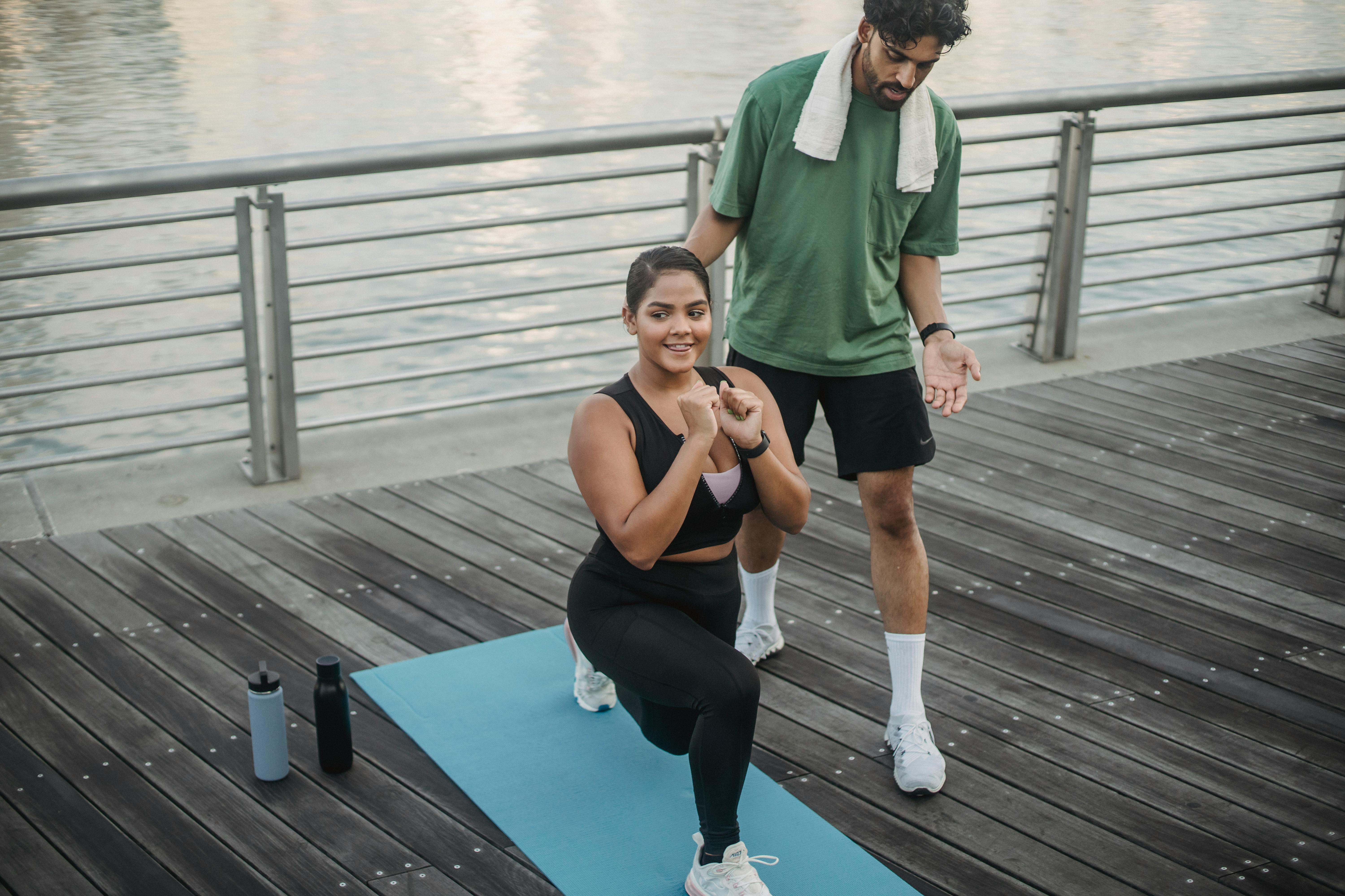 man guiding a woman doing leg stretching