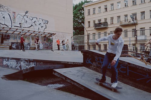 Man In Wit T Shirt En Rode Broek Staande Op Rood Skateboard