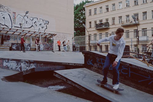 Hombre En Camiseta Blanca Y Pantalón Rojo De Pie En Patineta Roja