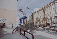 Man in White Long Sleeve Shirt and Denim Pants Playing Skateboard