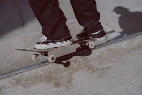 Kostenlos Person In Roten Hosen Und Weißen Turnschuhen, Die Auf Skateboard Reiten Stock-Foto