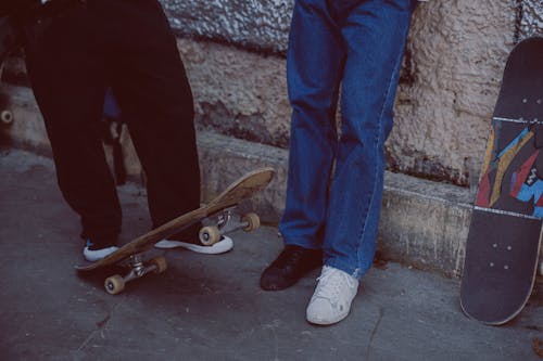 Orang Dengan Jeans Denim Biru Dan Sepatu Kulit Coklat Berdiri Di Samping Papan Luncur Kayu Coklat