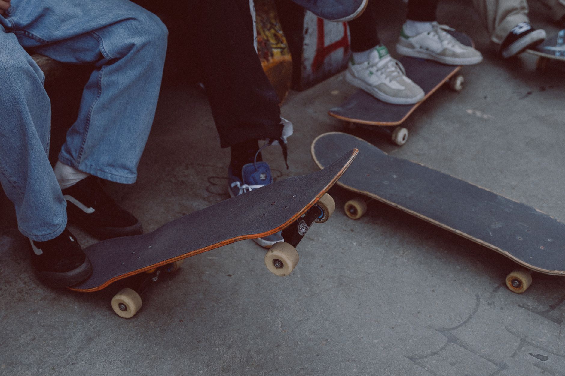 Houston skateboarding community gathering near a concrete bowl, old cameras and handmade decks visible