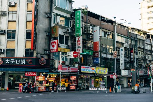 Colorful city street with diverse shops and signage in a bustling Asian metropolis.
