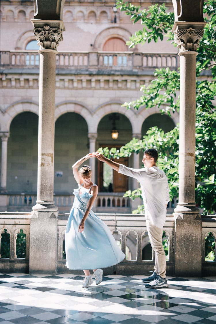 A Couple Dancing Together While Holding Hands