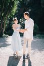 一对幸福的夫妇手牵手，在阳光明媚的户外散步，散发着欢乐与浪漫