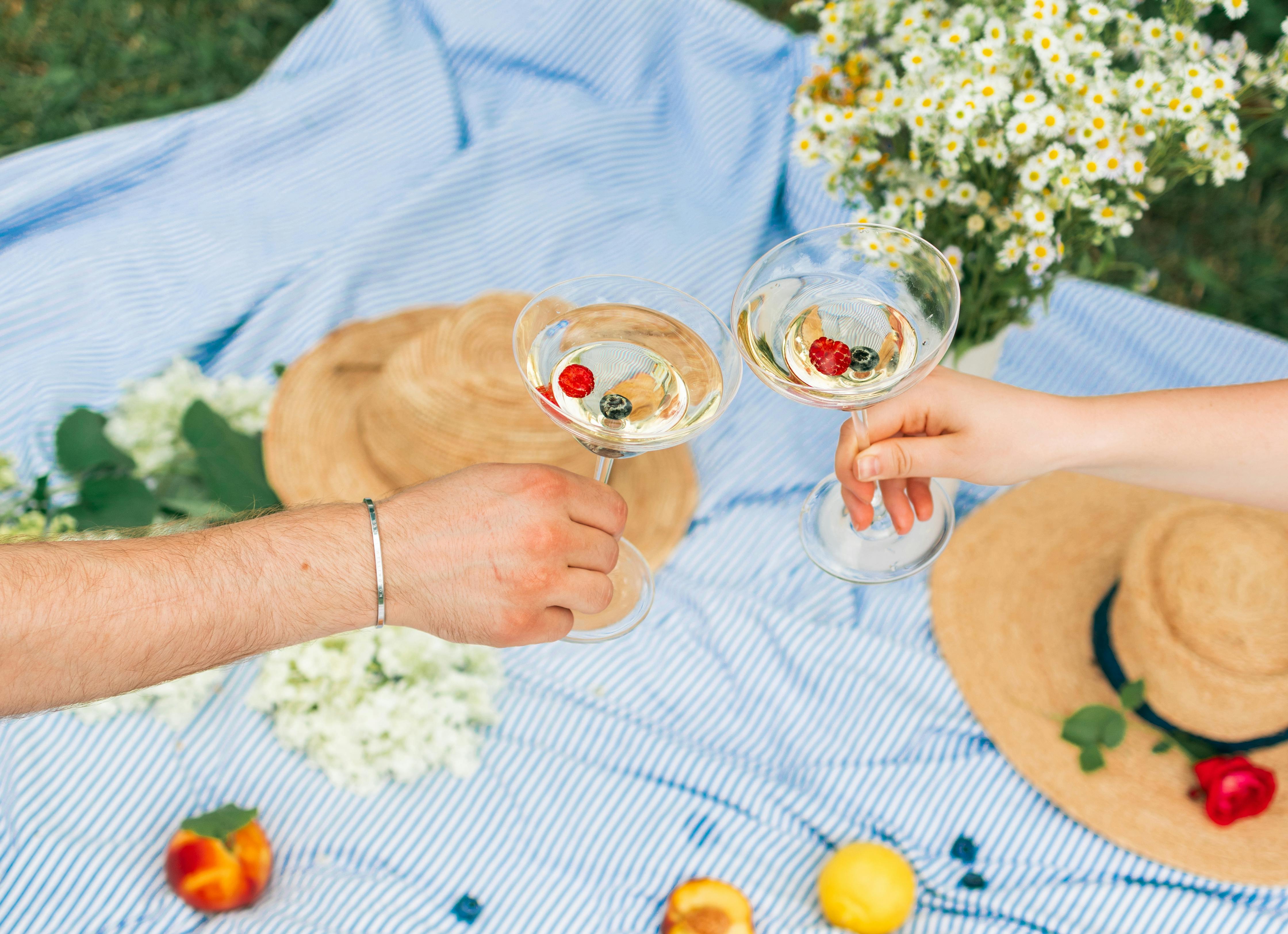 2 person holding clear drinking glasses