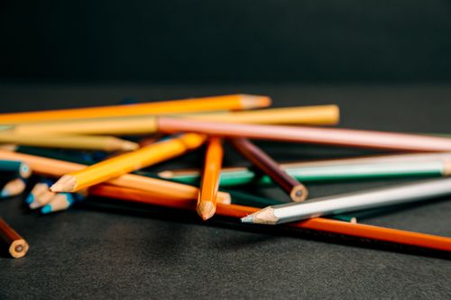 Free Bunch of pencils with sharpened tips lying on each other on dark table against black background in modern studio inside Stock Photo