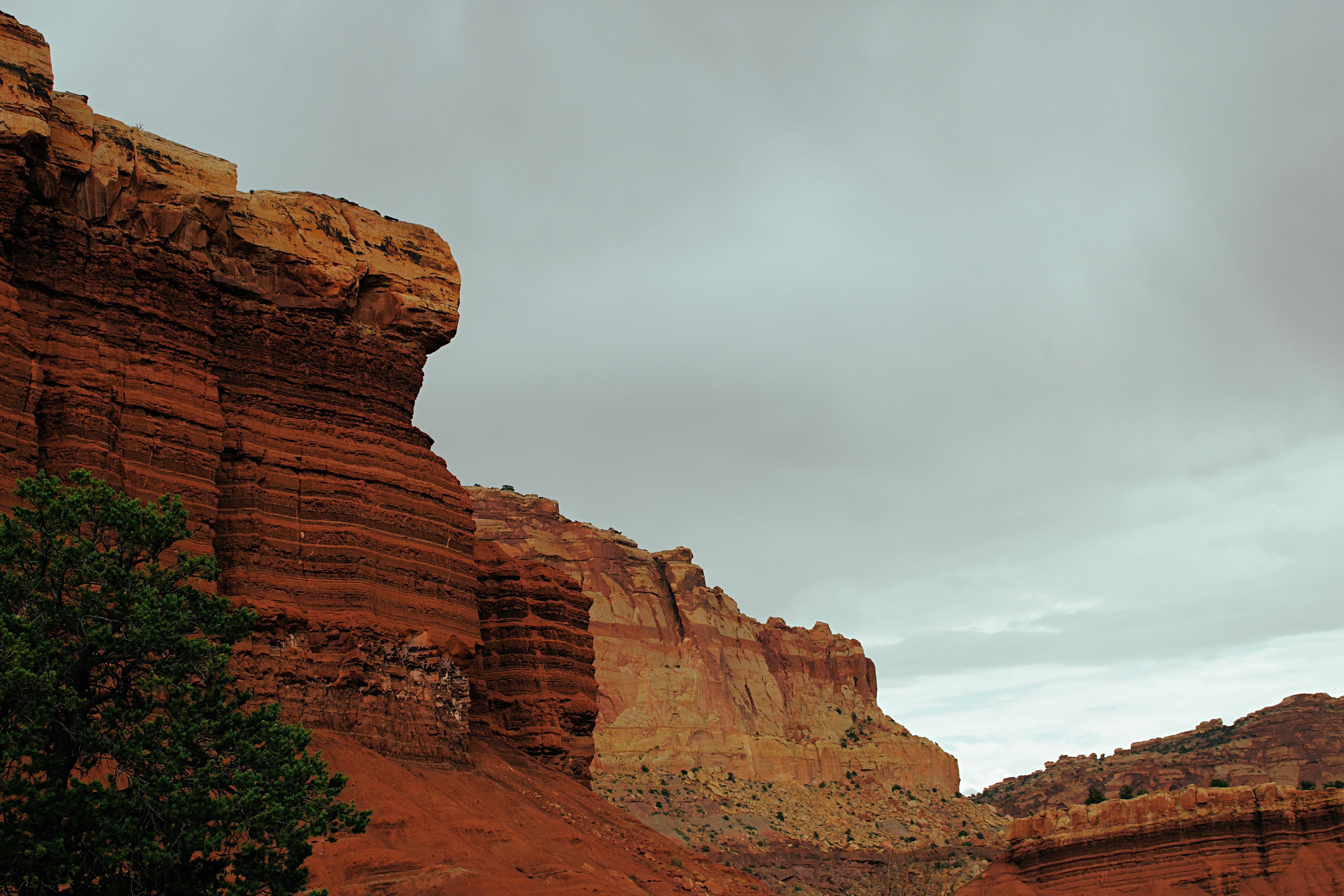 brown rock formation under white clouds