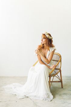 一位美丽的新娘头戴花卉发带，身着白色婚纱，优雅地摆出姿势