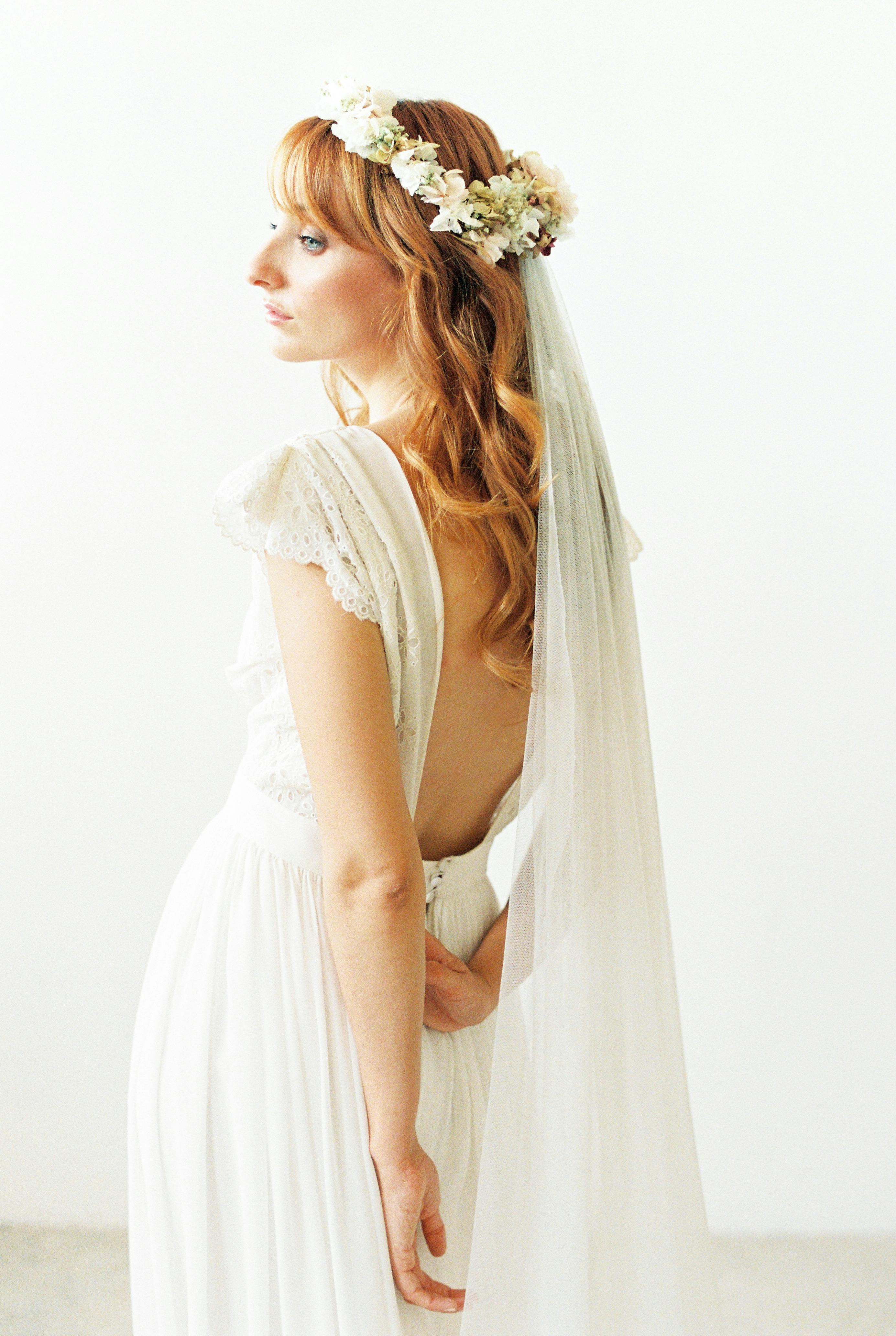 A serene portrait of a bride in a vintage gown and flower crown, exuding elegance and grace.
