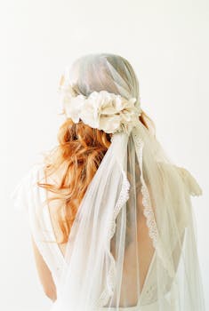 Back view of a bride in a bohemian style wedding veil and floral headpiece, showcasing elegance.