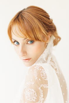 Charming bride posing in a lace wedding dress, showcasing elegance and style.