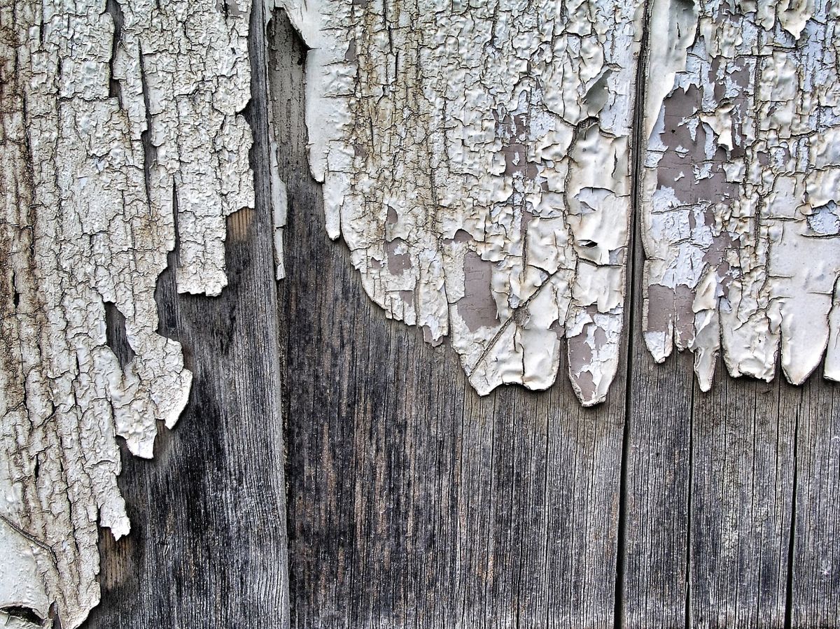 Peinture ancienne écaillée sur une porte en bois