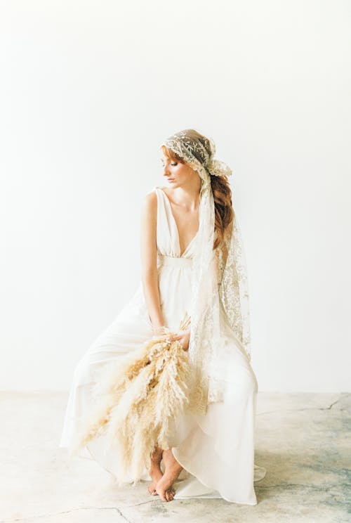 Woman in White Sleeveless Dress Holding Pampas Grass 