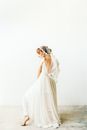 在光线充足的工作室里，一位优雅的新娘穿着飘逸的礼服，戴着精致的面纱，摆出姿势