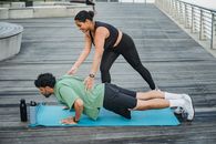 Woman in Black Tank Top and Green Pants Doing Yoga on Blue Mat