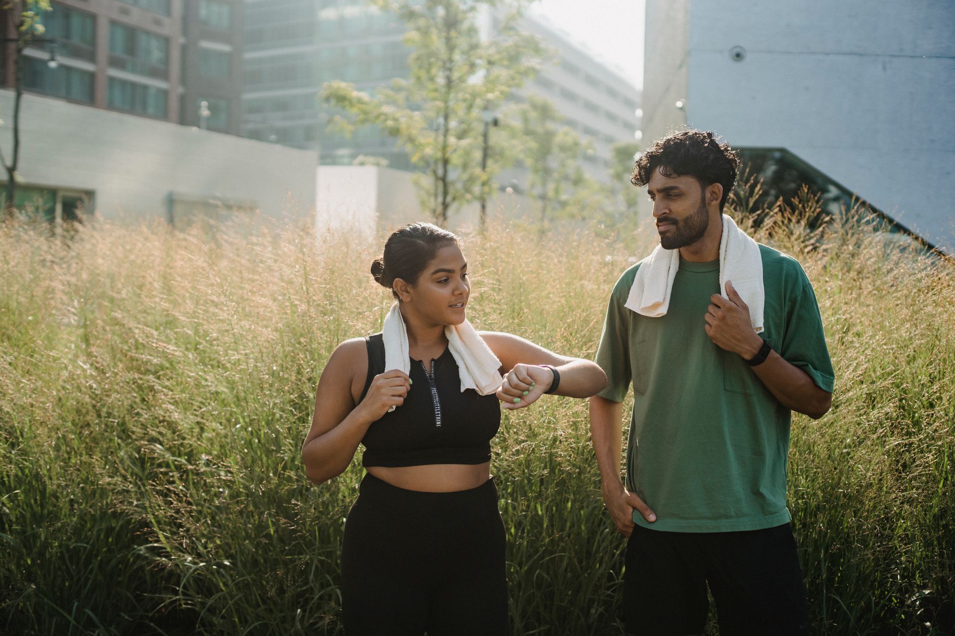 methylene blue nmn midlife energy crash — A couple enjoys a casual walk through a city park, carrying towels for exercise.