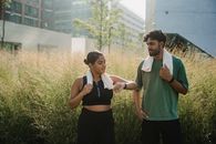 Man in Green Polo Shirt Standing Beside Woman in Black Tank Top